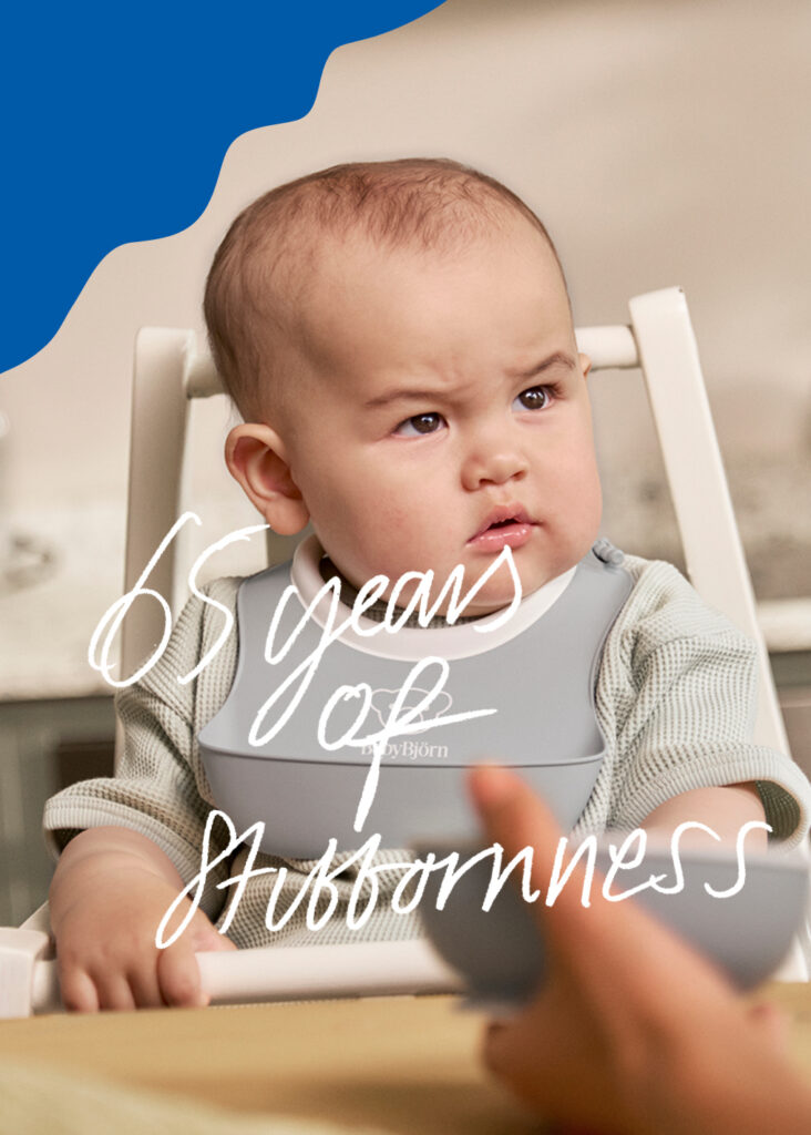 תינוק יושב לאכול עם סינר בייבי ביורן.